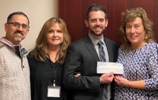 KDI team members present a donation check to the American Cancer Society's Northeast Region Community chapter.