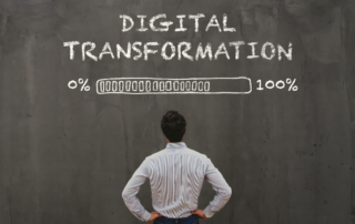 Digital transformation with loading percentage on a chalkboard in front of a businessman signifying conversion services