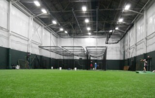 Indoor baseball training facility at All-Star Sports Academy with batting cages and turf lanes