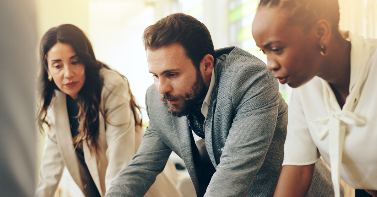 Business professionals collaborating around connected technology systems and workflows in a modern office environment.