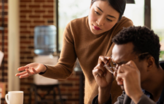 Employees searching through documents and digital systems during a business workflow discussion