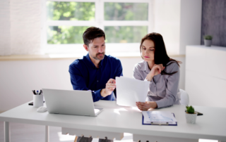 Business professionals reviewing Microsoft 365 security settings and technology recommendations on a laptop.