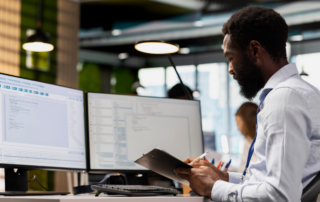 Employee reviewing business information across multiple systems and digital workspaces.