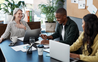 Small business employees using laptops and technology in an office