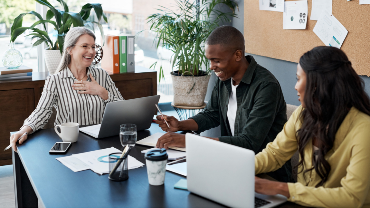 Small business employees using laptops and technology in an office