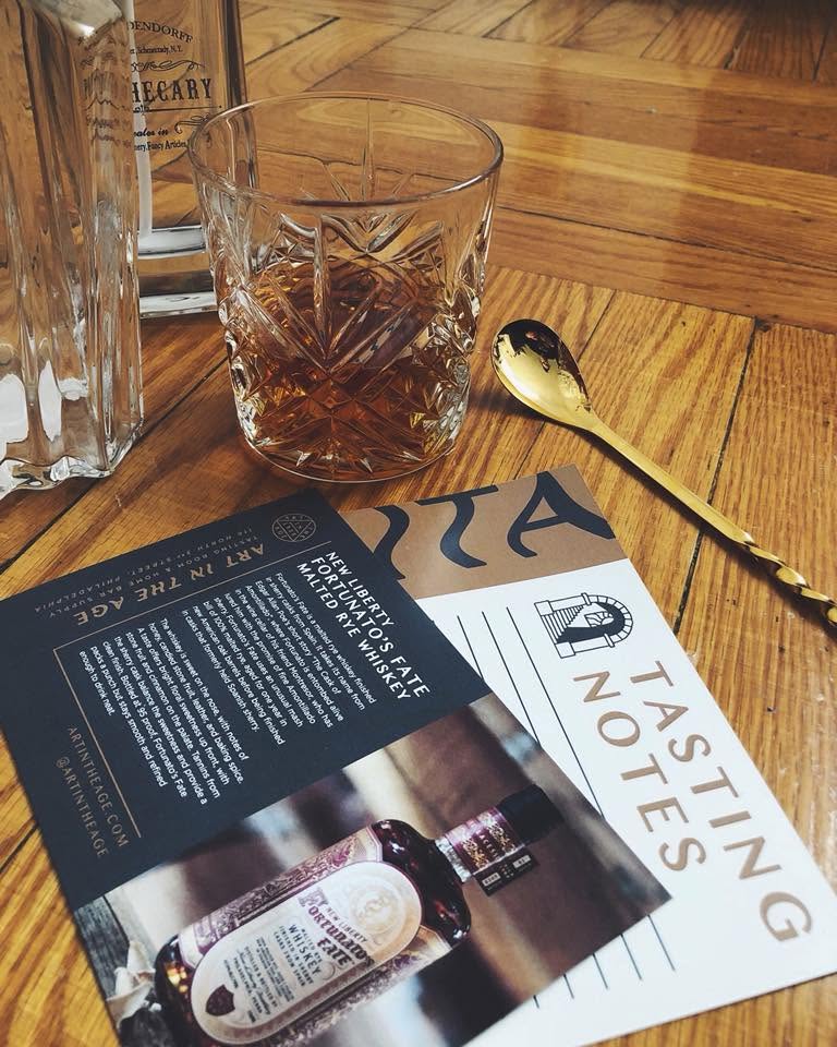 Custom printed New Liberty Distillery Tasting Notes brochure displayed alongside a whiskey glass.